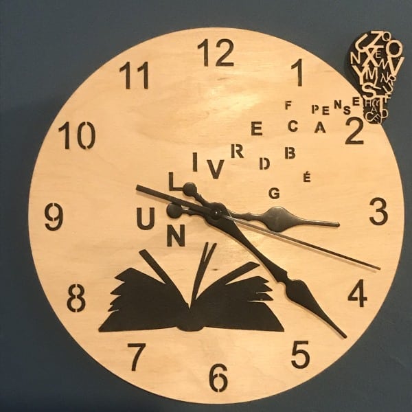 Horloge design bois et noir avec un motif en forme de livre